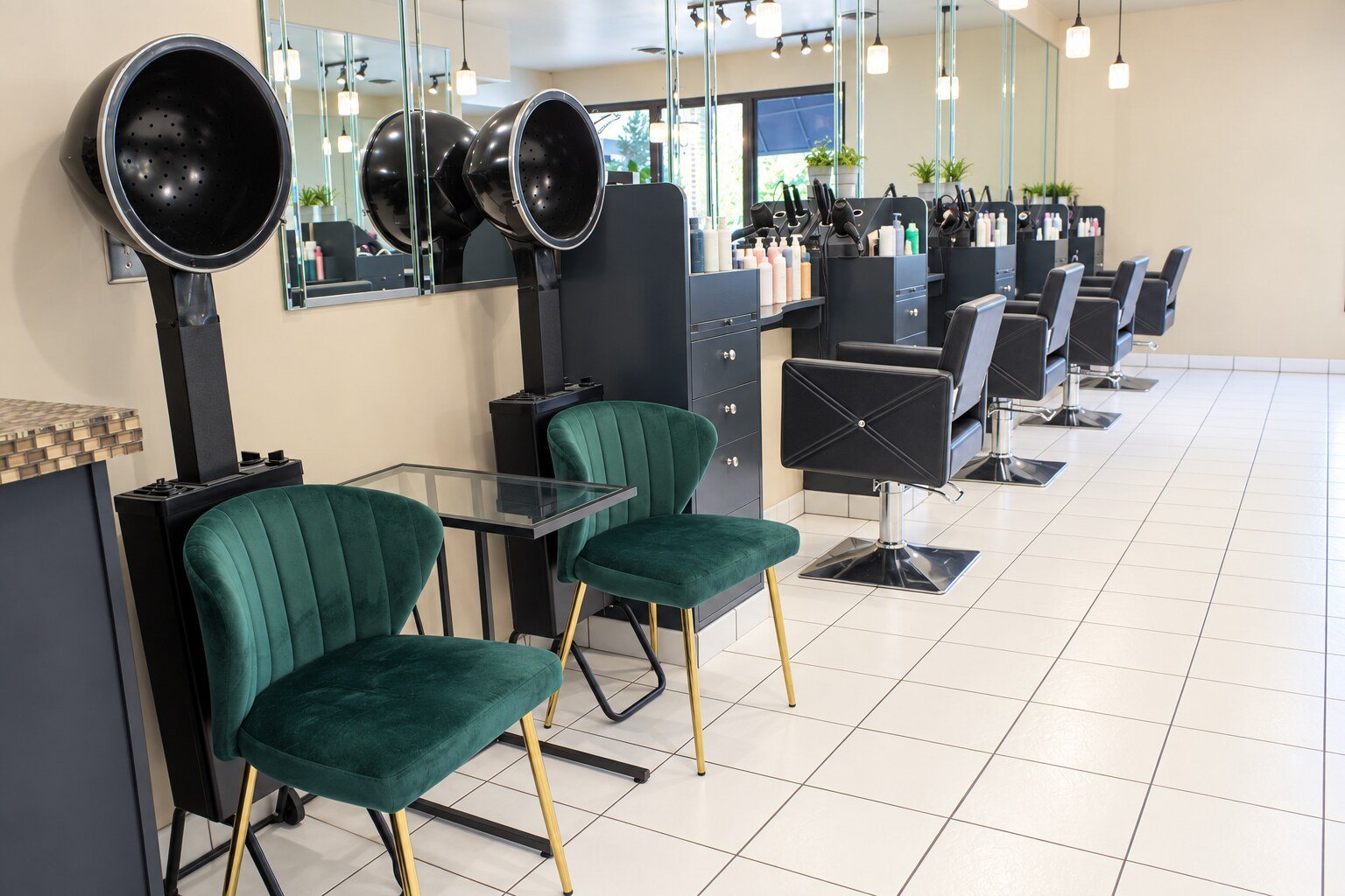 Green velvet chairs under the hood dryers