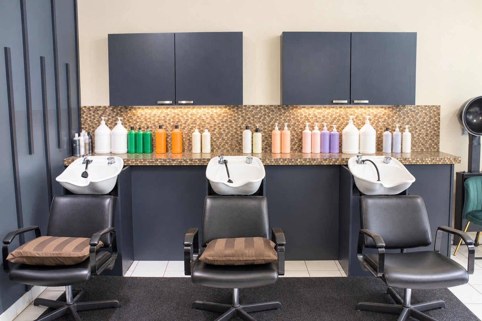 Three shampoo bowls under navy cabinets